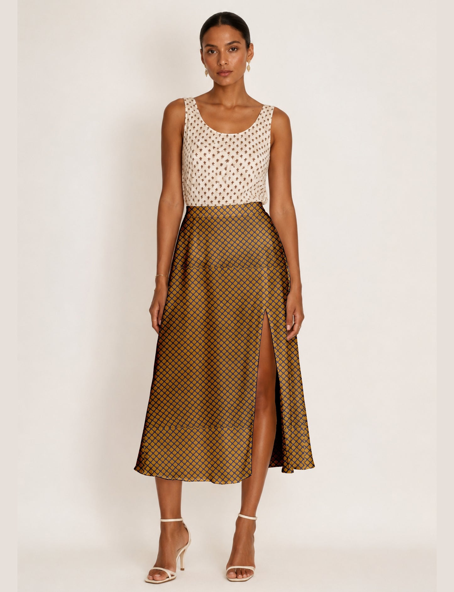 Woman wearing a yellow A-line skirt with a micro diamond pattern and front slit, paired with a sleeveless white patterned