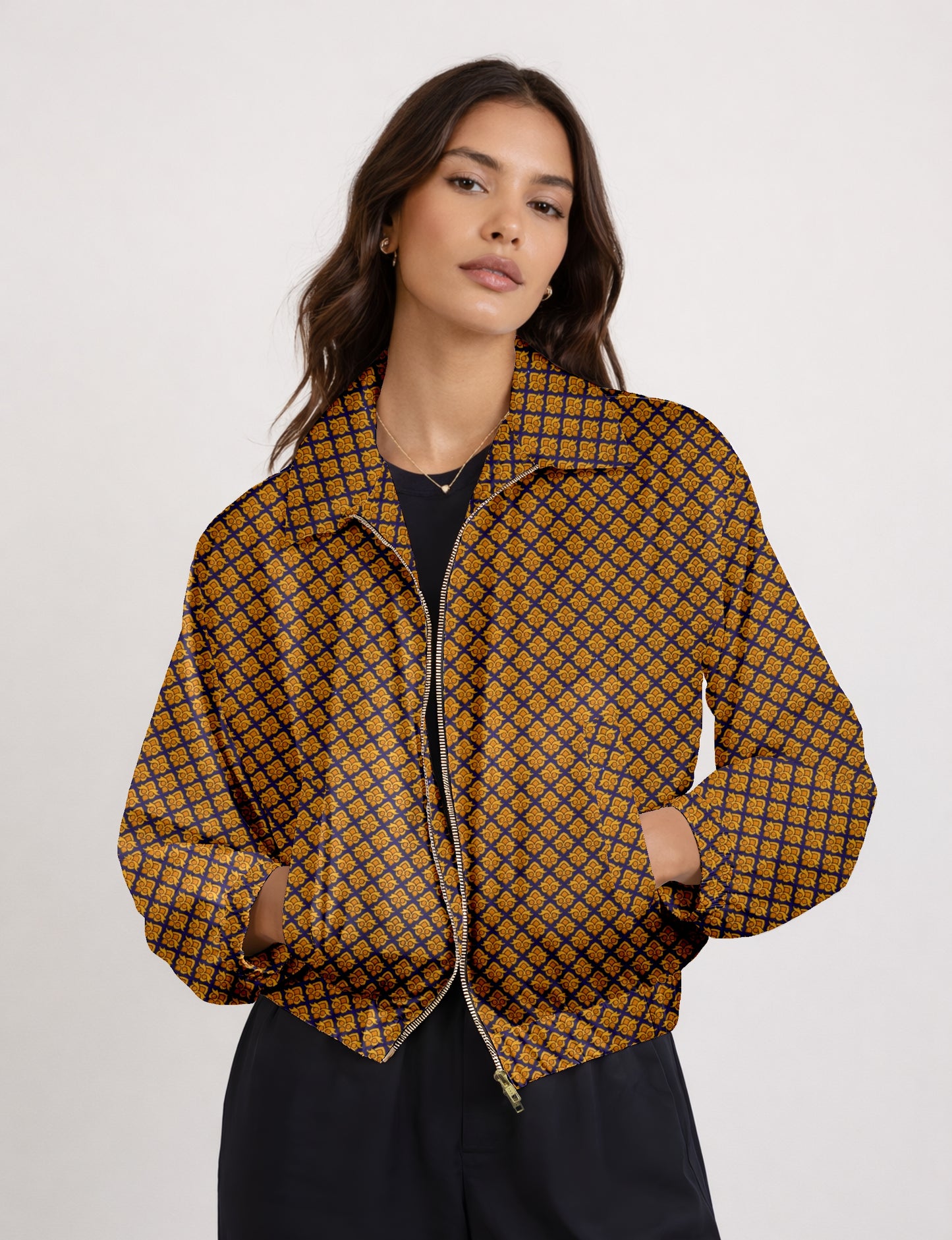 Woman wearing a yellow bomber jacket with a micro geometric pattern, front zipper, and side pockets, paired with black pants