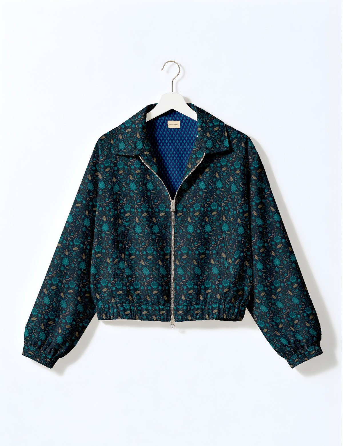 Brown floral bomber jacket with front zipper, elastic cuffs and hem, hanging on white hanger, red floral inner lining visible
