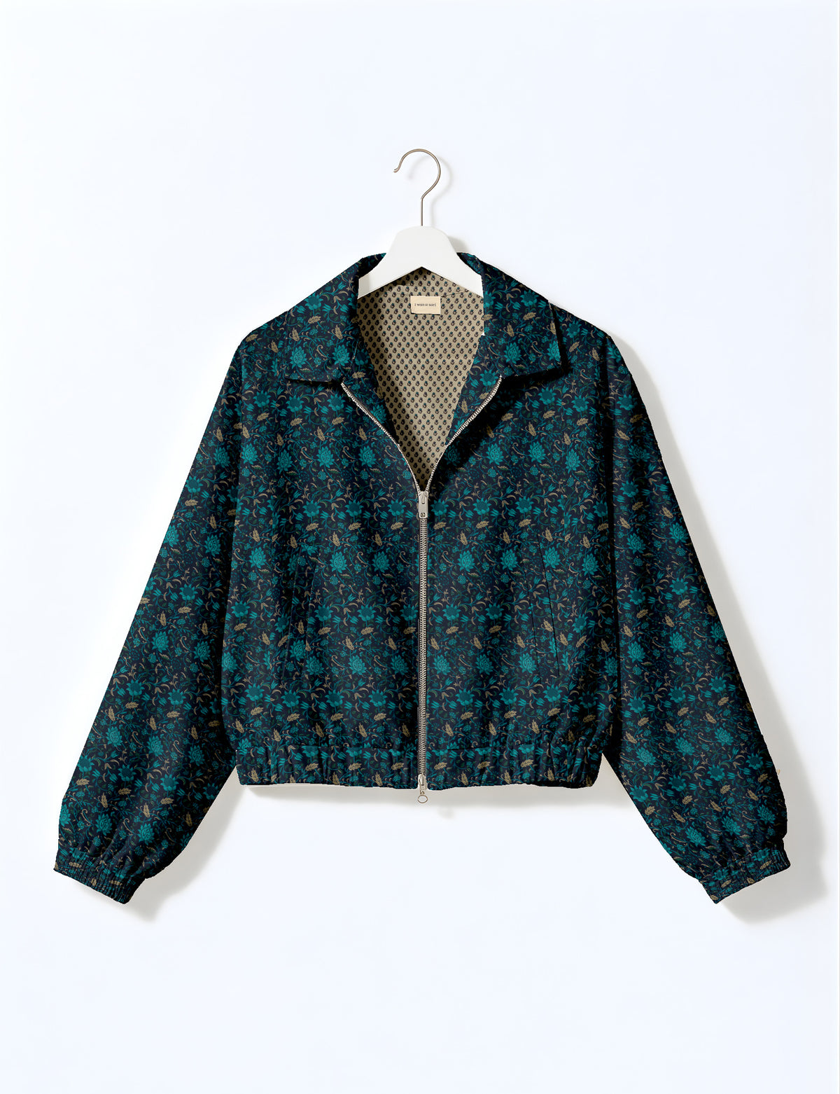 Brown floral bomber jacket with front zipper, elastic cuffs and hem, hanging on white hanger, red floral inner lining visible