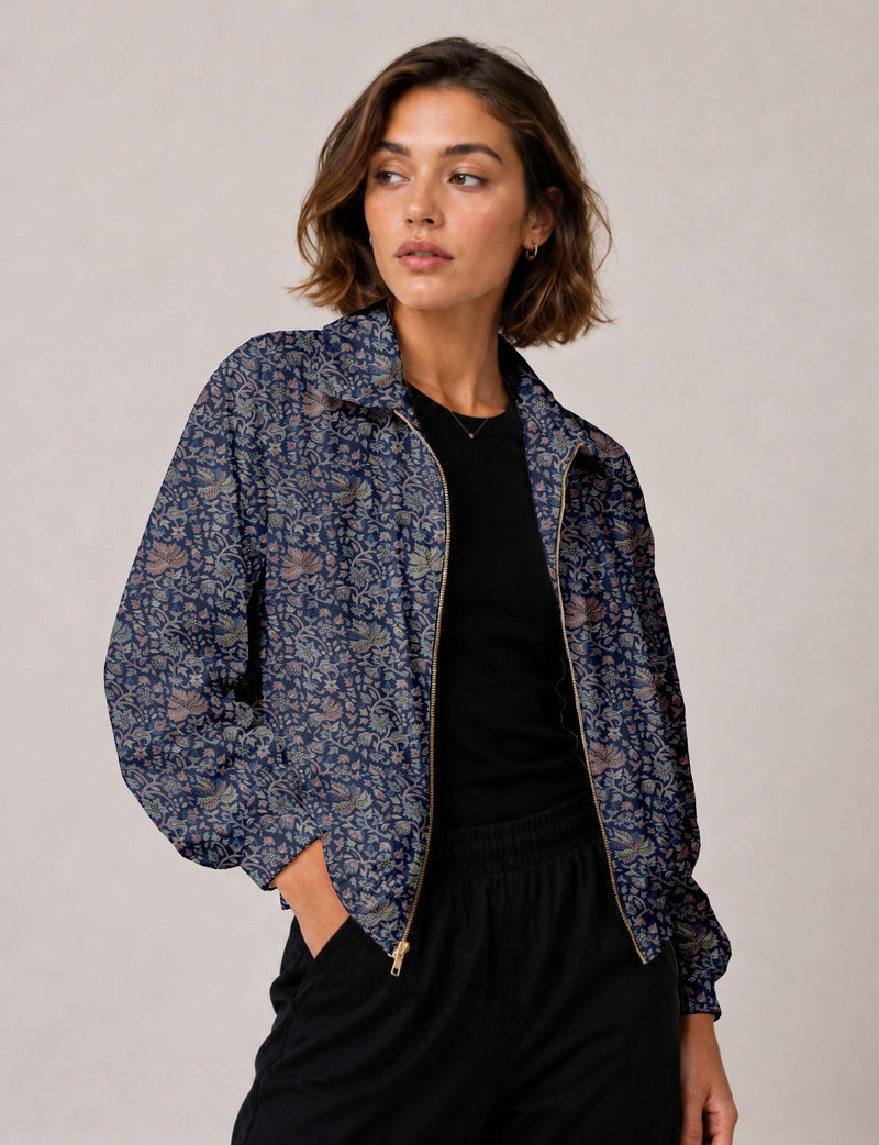 Woman wearing a yellow floral bomber jacket with front zipper, elastic cuffs, and side pockets, shown from front view