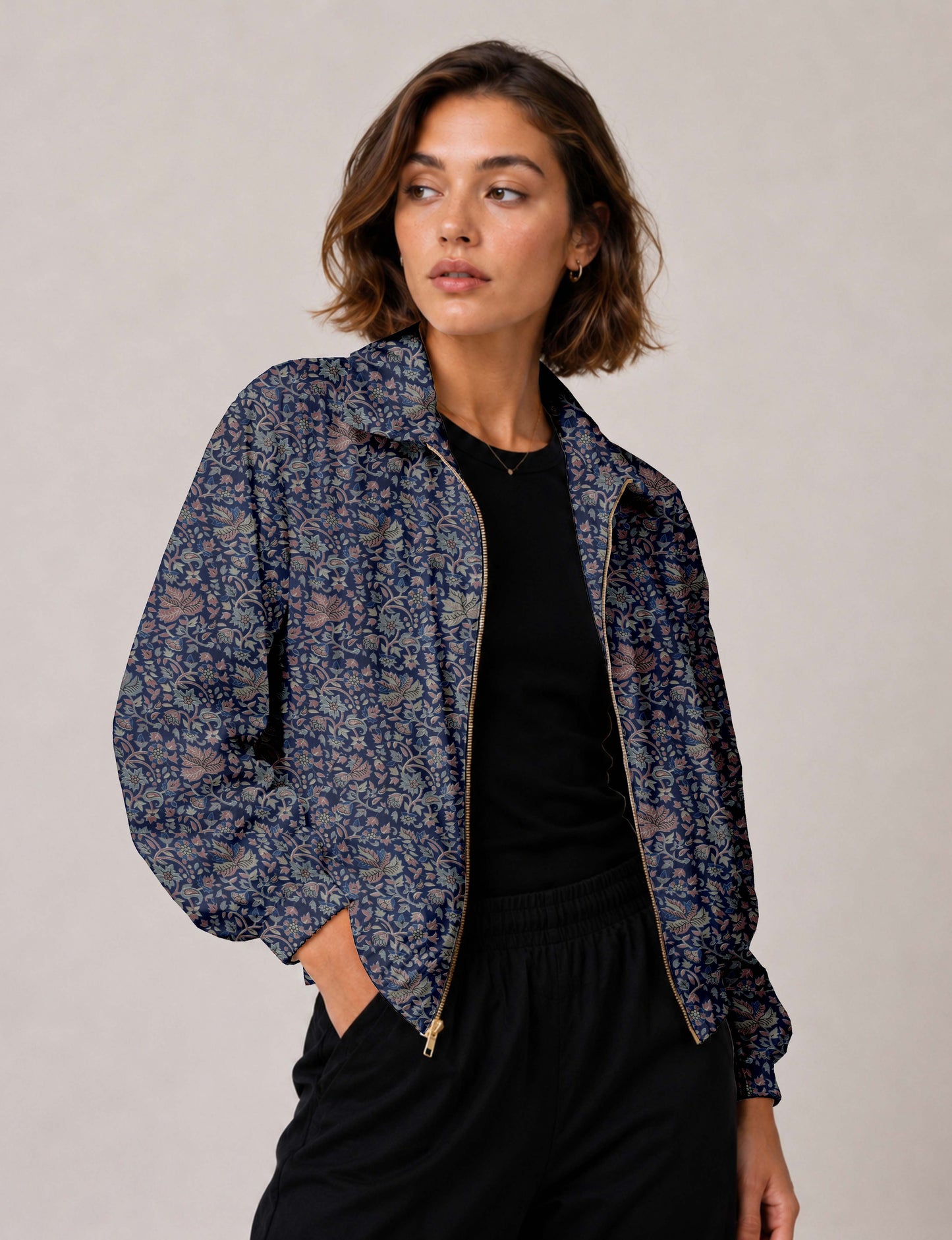 Brown floral bomber jacket with front zipper, elastic cuffs and hem, hanging on white hanger, red floral inner lining visible
