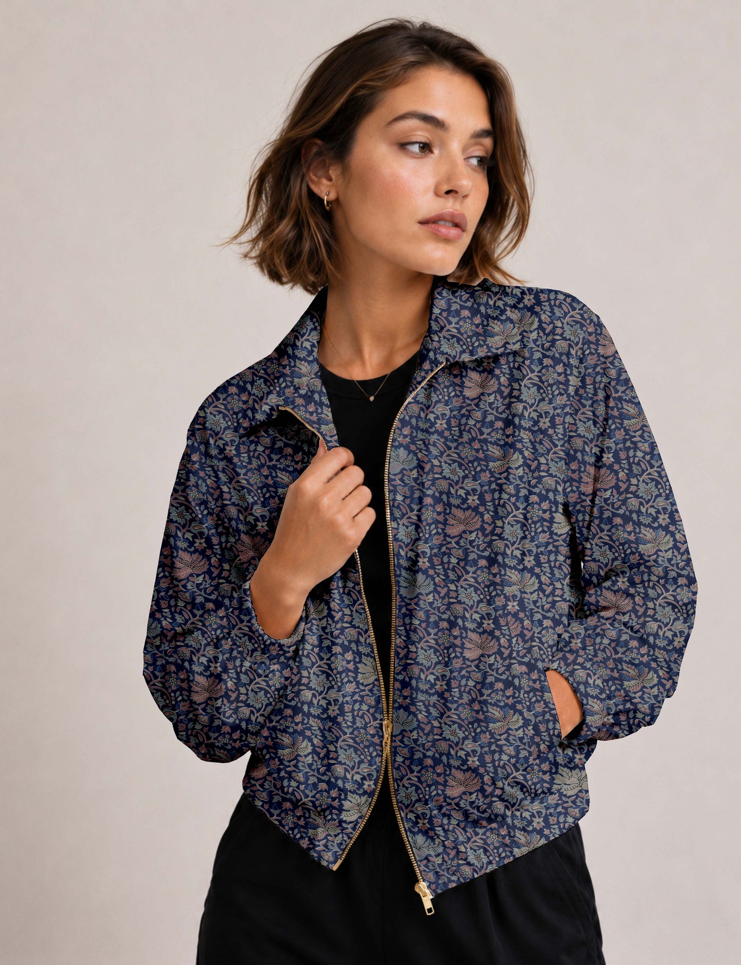 Woman wearing a yellow floral bomber jacket with front zipper, elastic cuffs, and side pockets, shown from front view