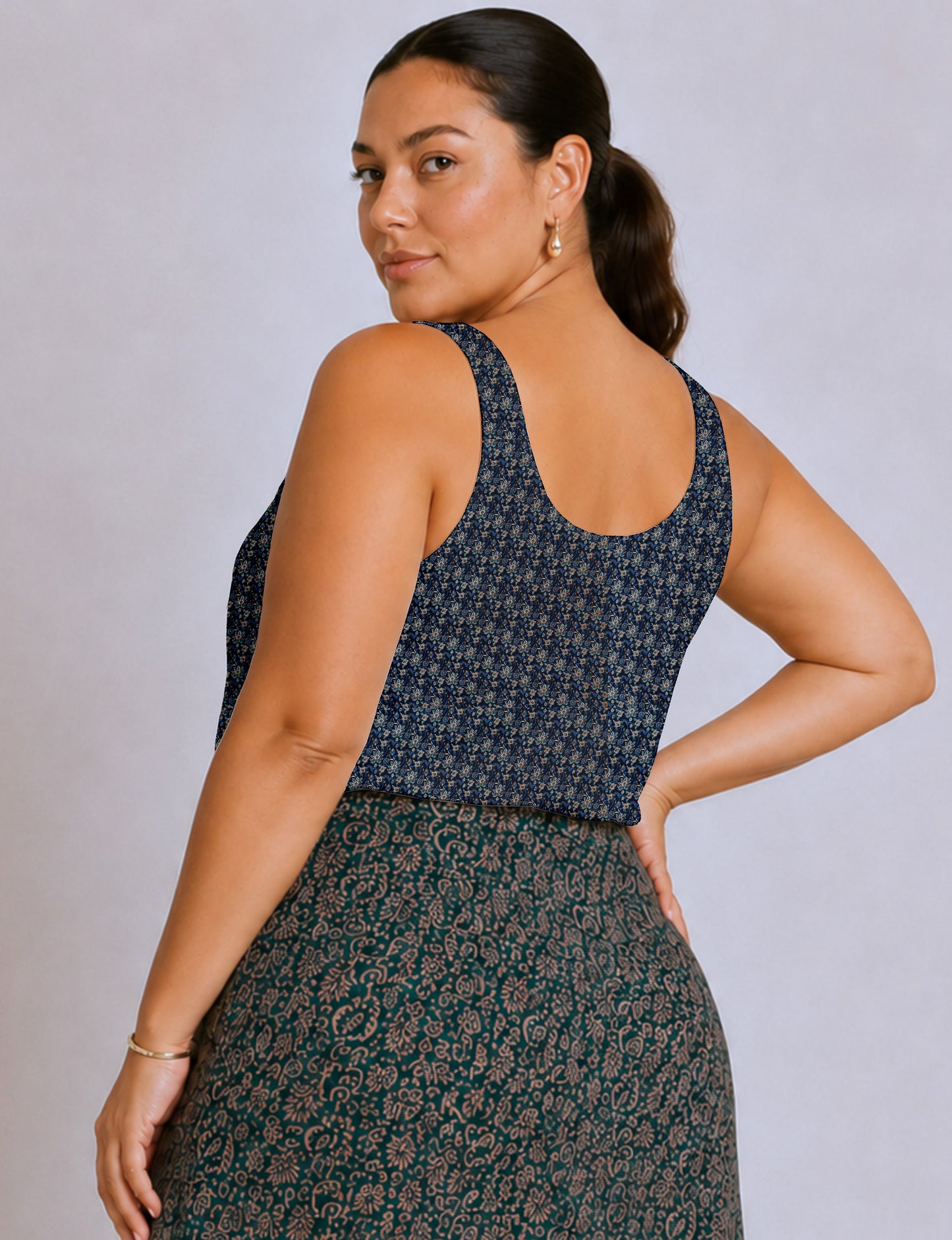 Women's sleeveless blouse with a relaxed straight fit, wide scoop neckline, deep scoop back, and hip-length silhouette.