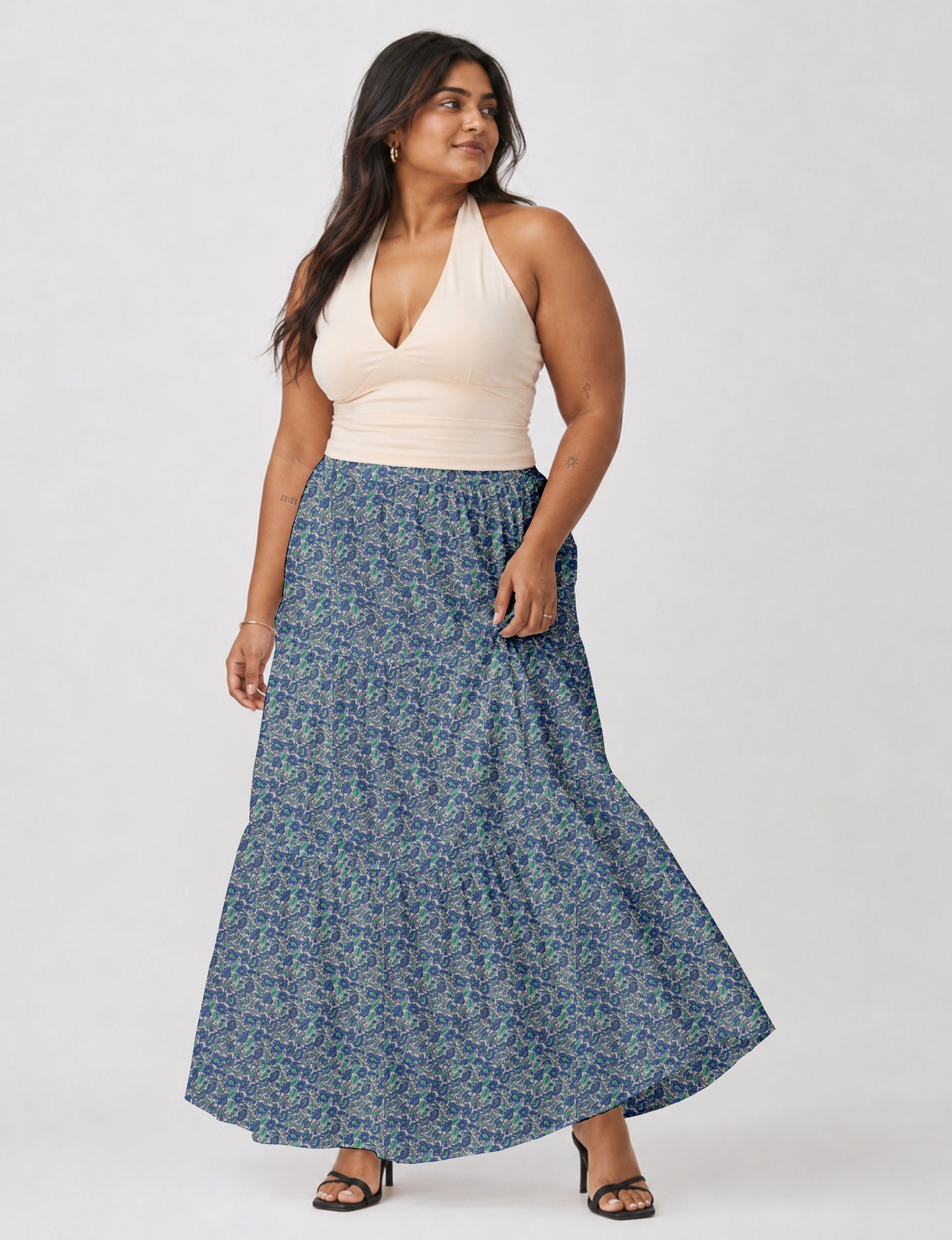 Woman wearing a yellow midi tiered skirt with a small geometric pattern, paired with a beige strapless top and white heels