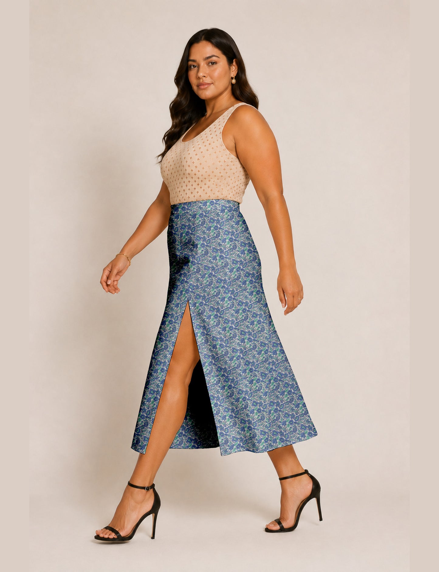 Woman wearing a yellow and black micro patterned A-line skirt with front slit, paired with beige sleeveless top and black