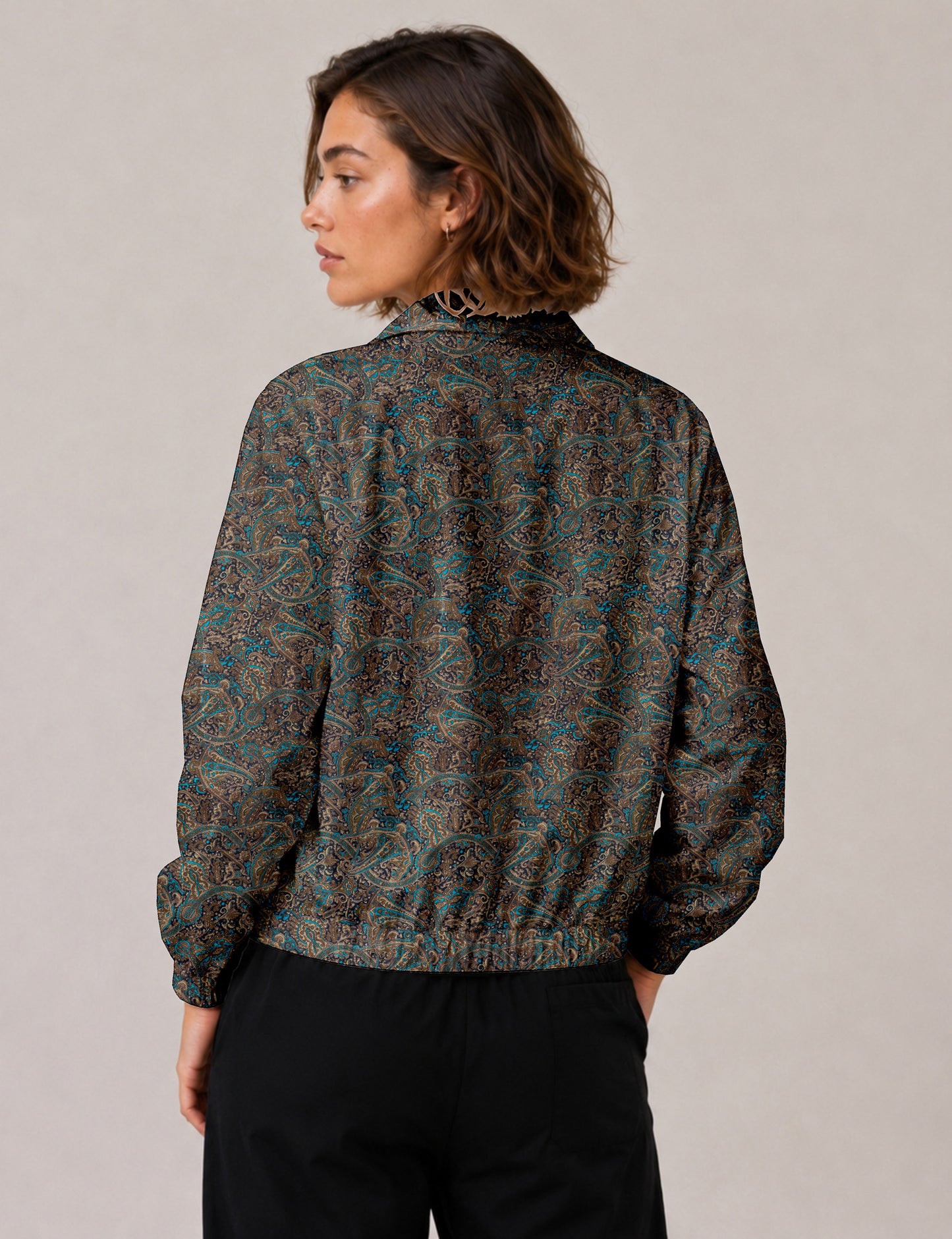 Woman wearing a yellow floral bomber jacket with front zipper, elastic cuffs, and side pockets, shown from front view