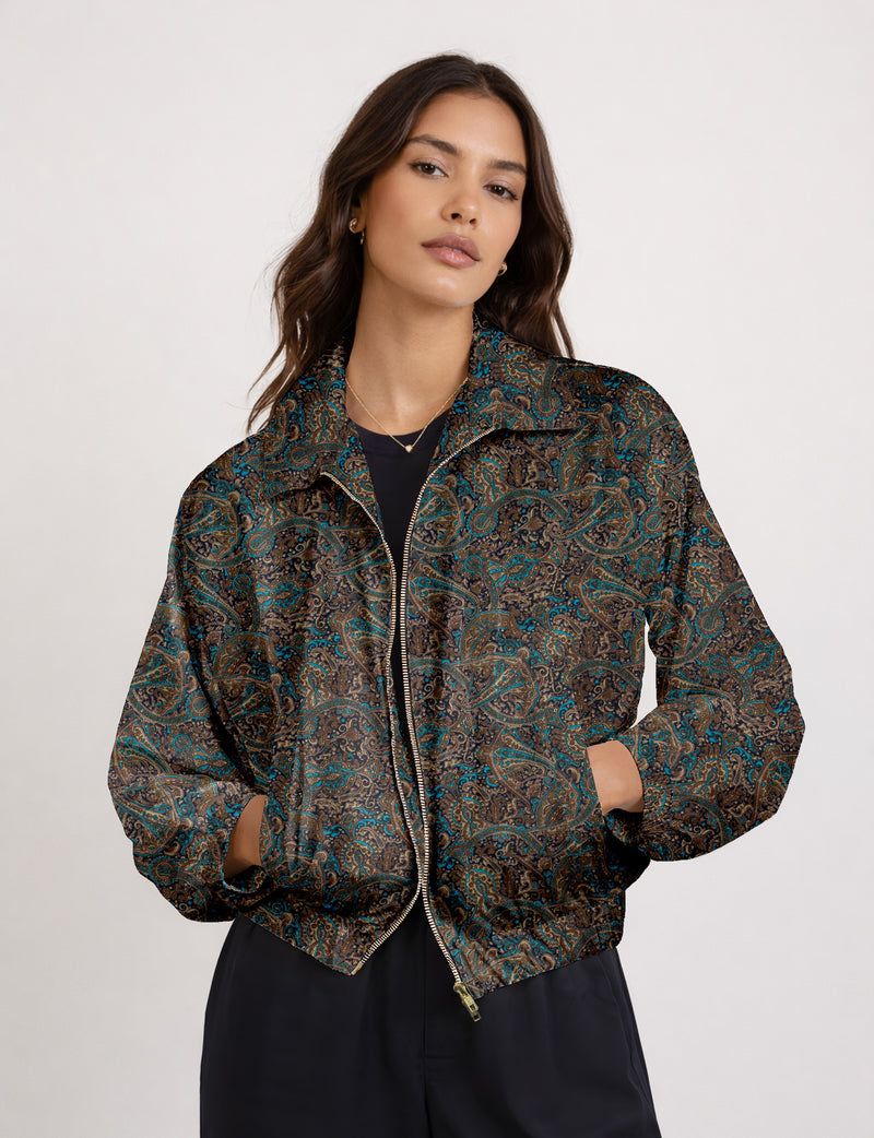 Woman wearing a yellow floral bomber jacket with front zipper, elastic cuffs, and side pockets, shown from front view