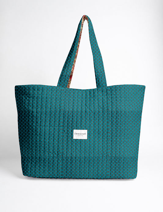 Quilted yellow tropical patterned beach bag with long handles and white label reading "I was a sari" front view