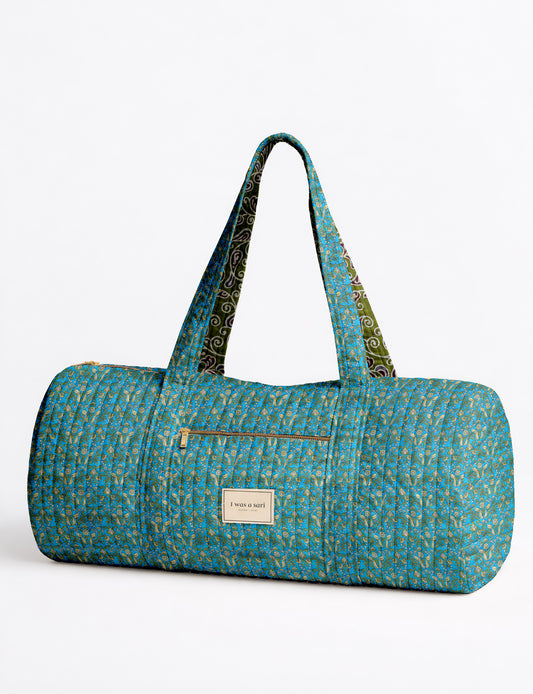Brown paisley quilted bowling bag with dual handles, front zipper pocket, and "I was a sari" label on front side