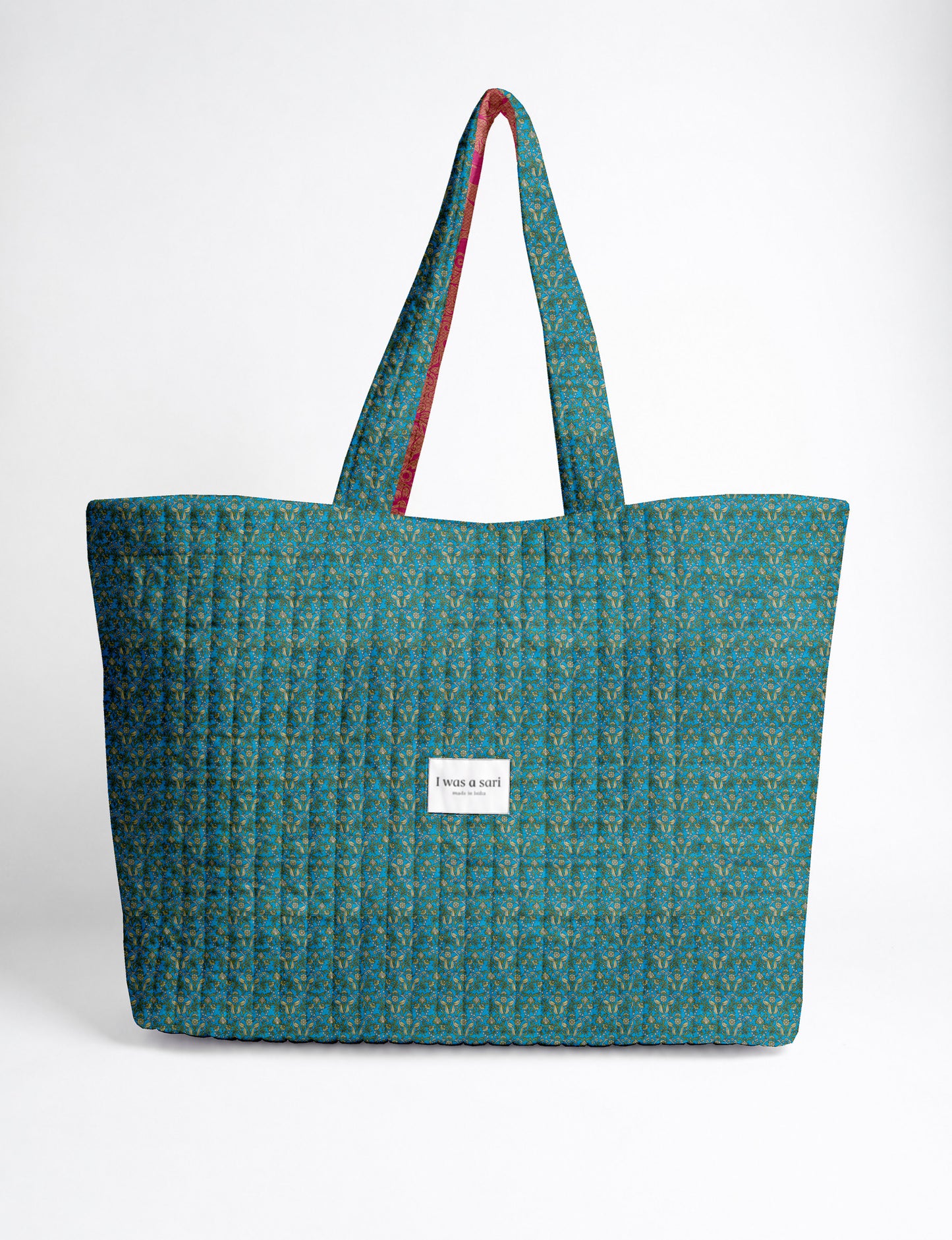 Quilted yellow tropical patterned beach bag with long handles and white label reading "I was a sari" front view
