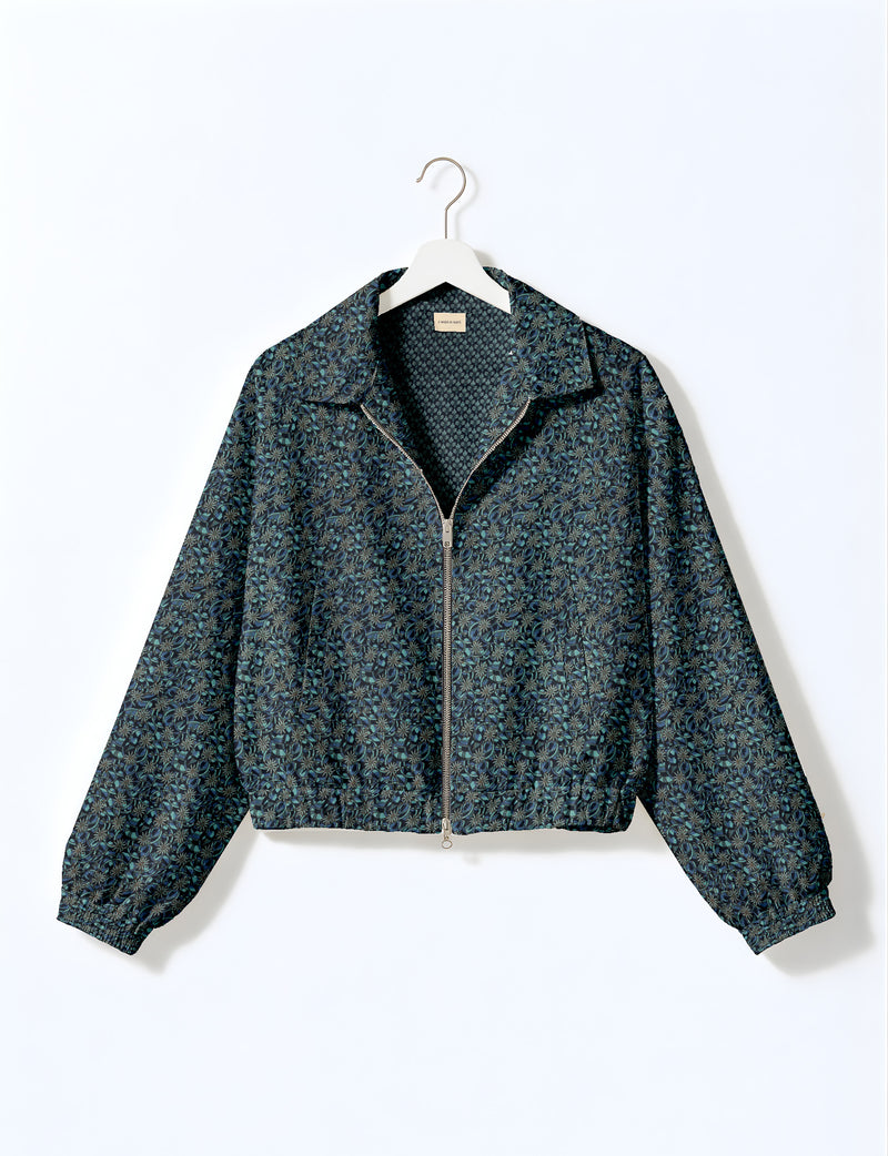 Brown floral bomber jacket with front zipper, elastic cuffs and hem, hanging on white hanger, red floral inner lining visible