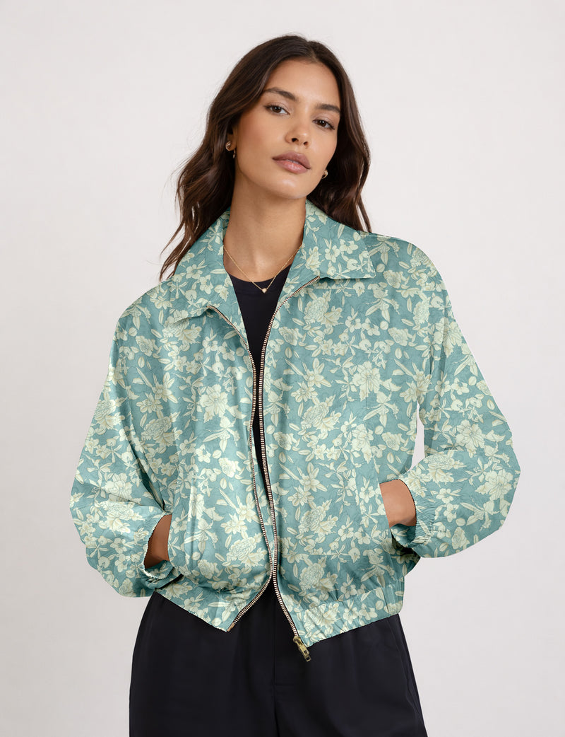 Brown floral bomber jacket with front zipper, elastic cuffs and hem, hanging on white hanger, red floral inner lining visible