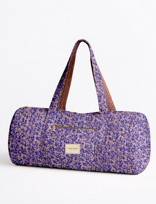 Brown paisley quilted bowling bag with dual handles, front zipper pocket, and "I was a sari" label on front side