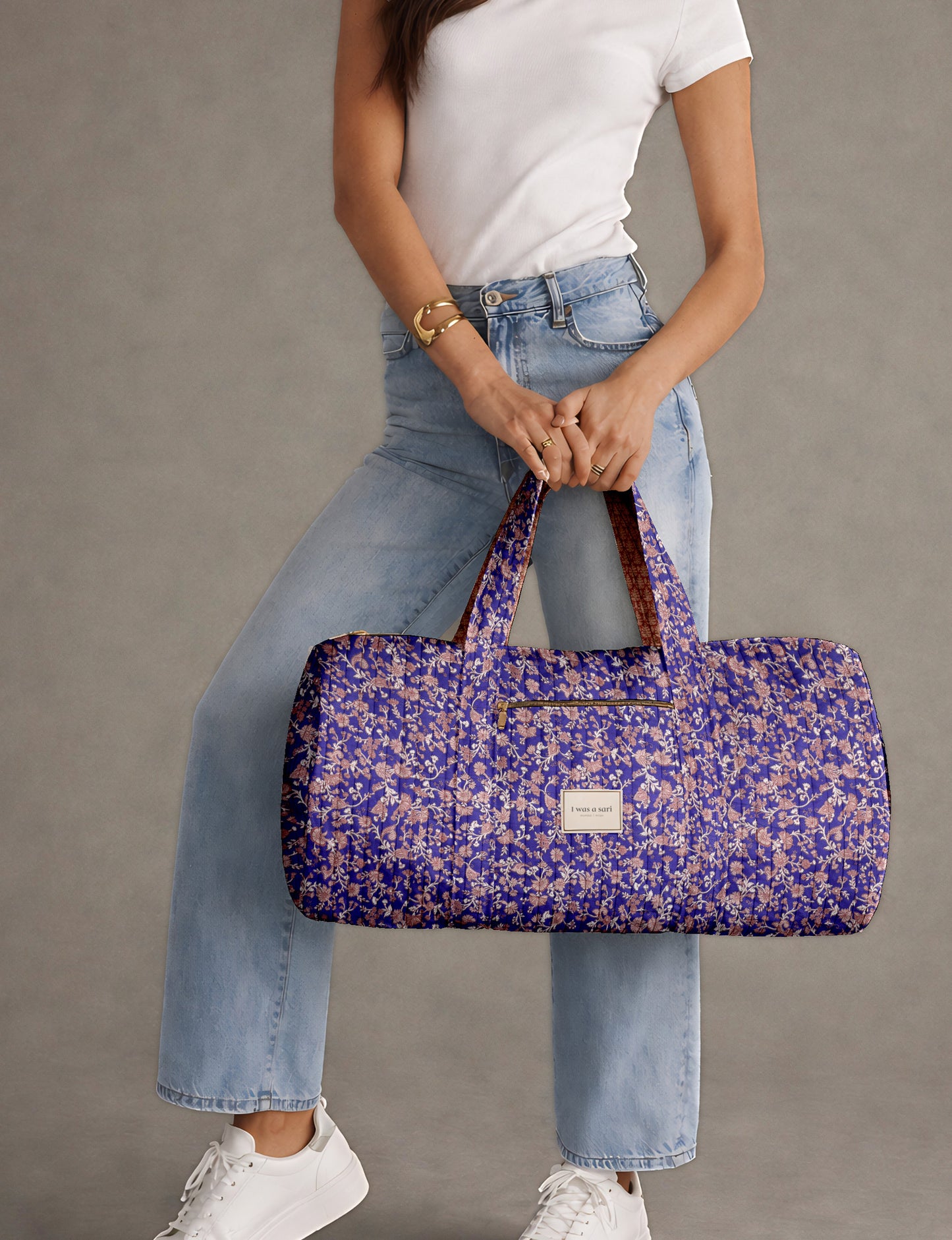 Brown paisley quilted bowling bag with dual handles, front zipper pocket, and "I was a sari" label on front side