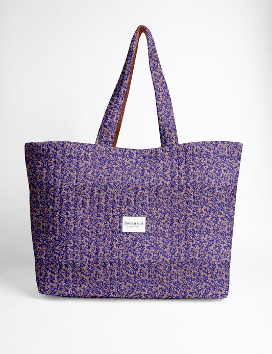 Quilted yellow tropical patterned beach bag with long handles and white label reading "I was a sari" front view