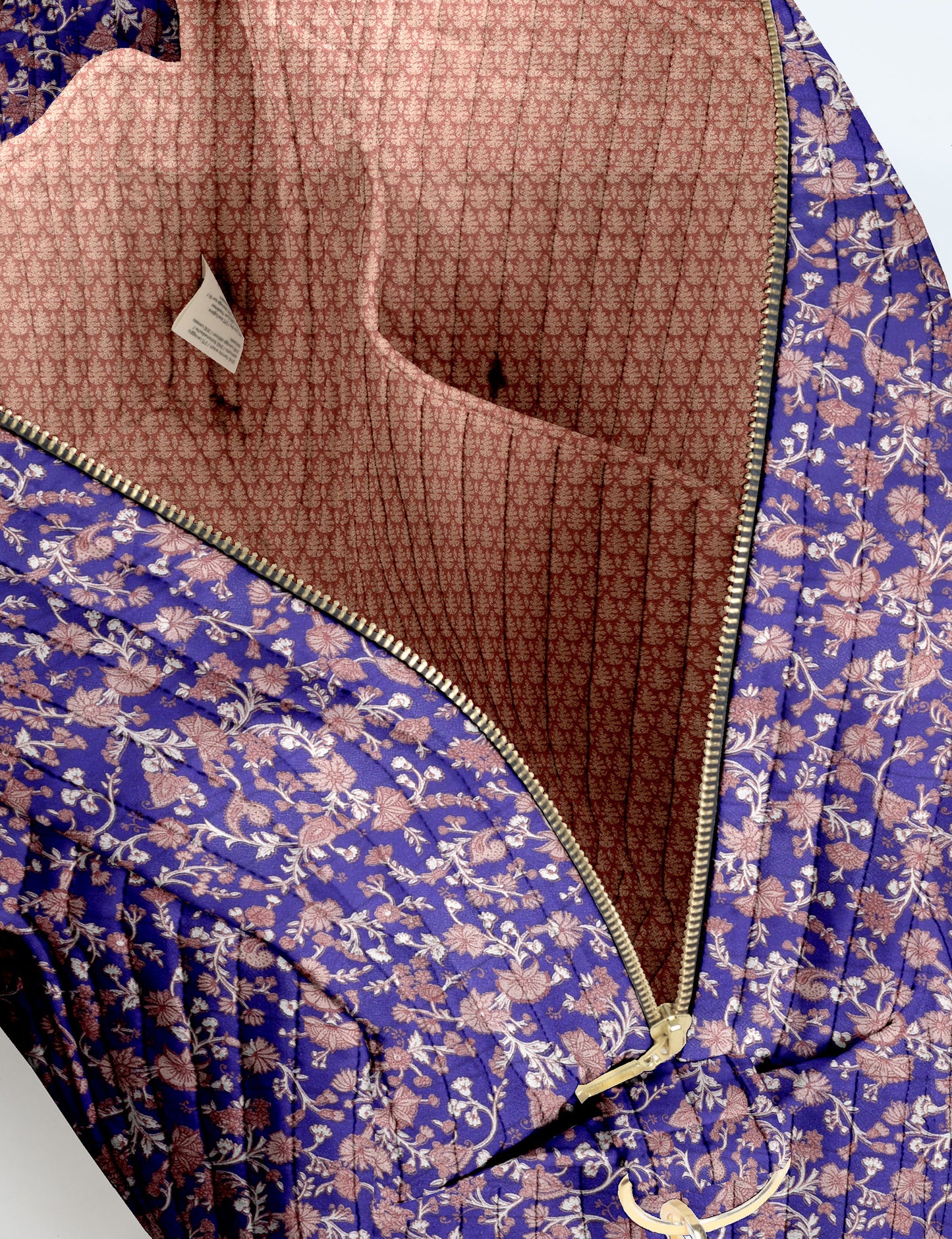 Brown quilted duffle bag with paisley pattern, front zip pocket, dual handles, and label reading "I was a sari"