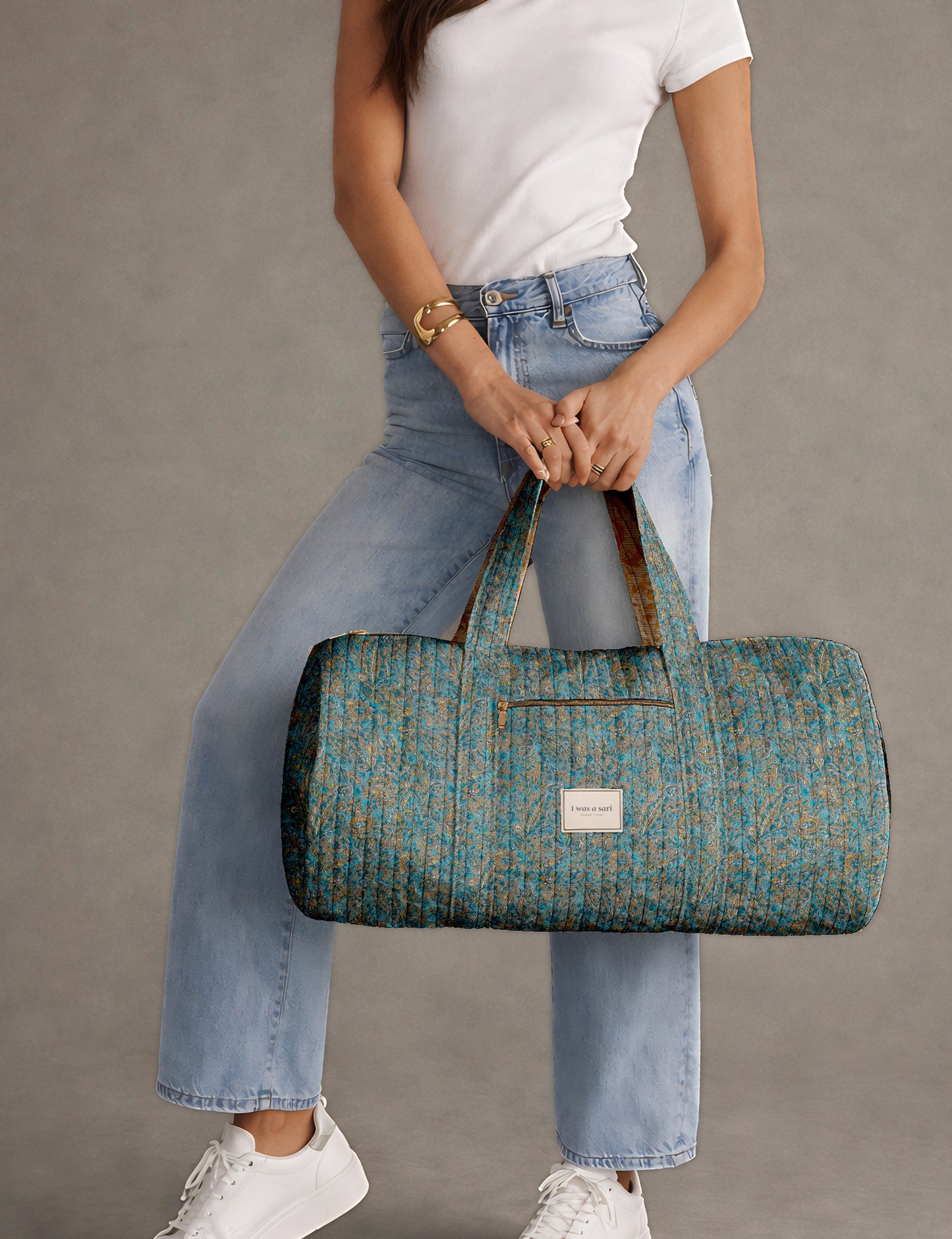 Brown paisley quilted bowling bag with dual handles, front zipper pocket, and "I was a sari" label on front side