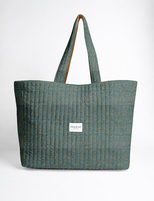 Quilted yellow tropical patterned beach bag with long handles and white label reading "I was a sari" front view