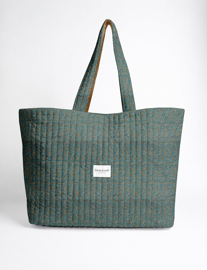 Quilted yellow tropical patterned beach bag with long handles and white label reading "I was a sari" front view