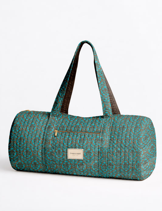 Brown paisley quilted bowling bag with dual handles, front zipper pocket, and "I was a sari" label on front side
