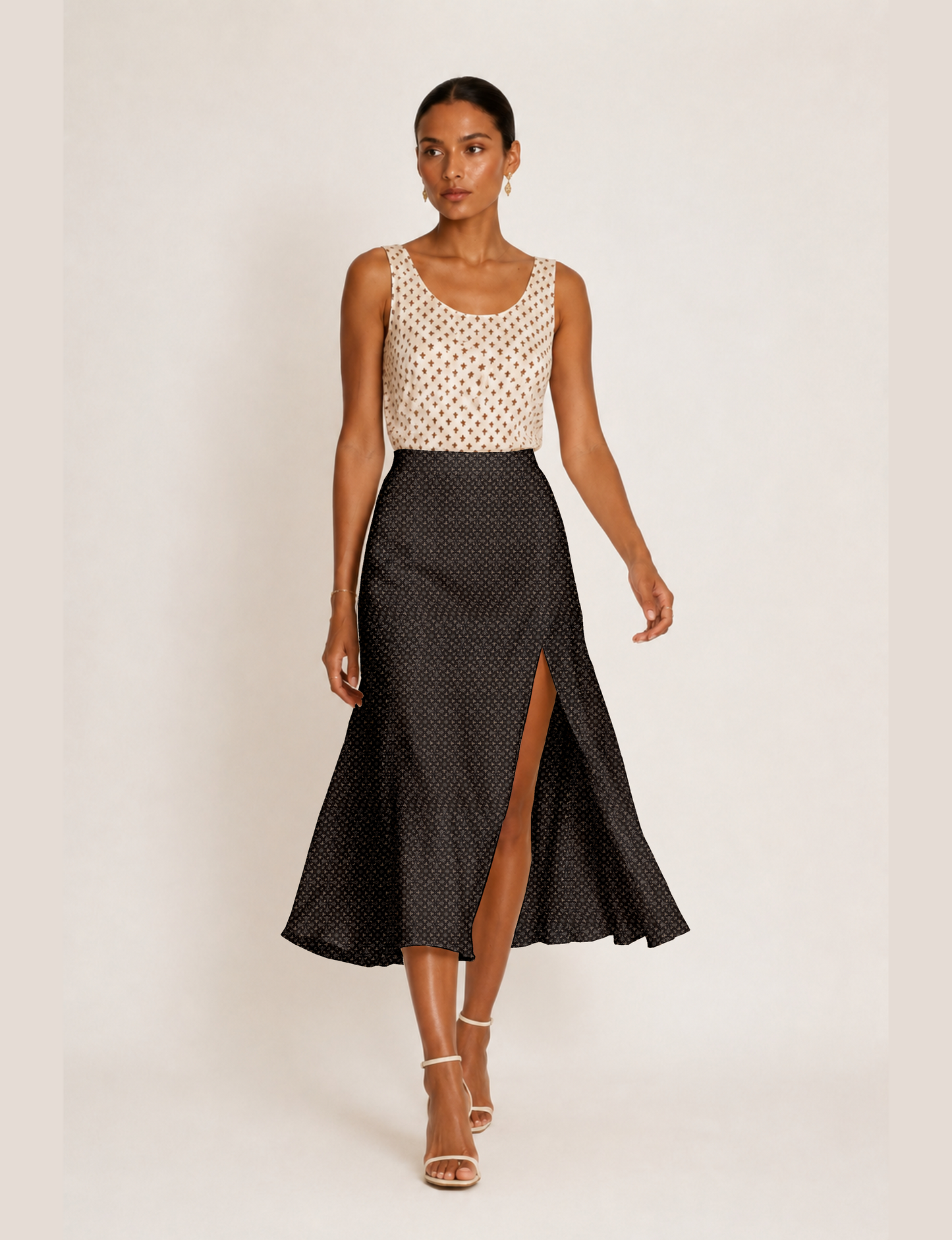 Woman wearing a yellow and black micro patterned A-line skirt with front slit, paired with beige sleeveless top and black