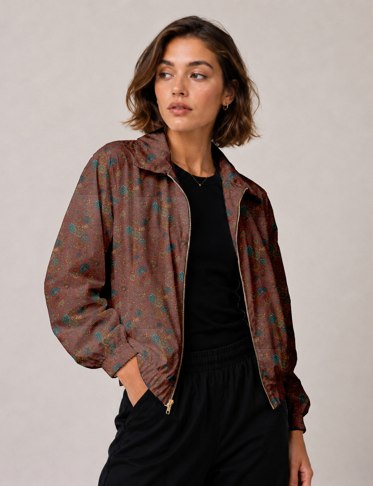 Woman wearing a yellow floral bomber jacket with front zipper, elastic cuffs, and side pockets, shown from front view