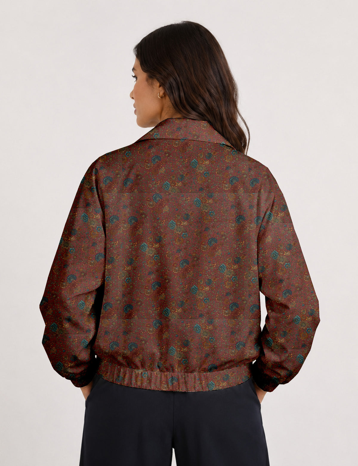 Woman wearing a yellow floral bomber jacket with front zipper, elastic cuffs, and side pockets, shown from front view