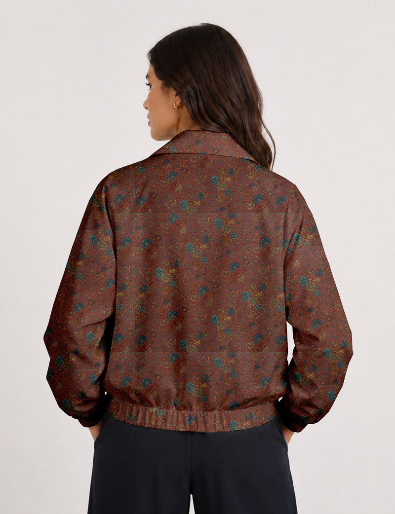 Woman wearing a yellow floral bomber jacket with front zipper, elastic cuffs, and side pockets, shown from front view