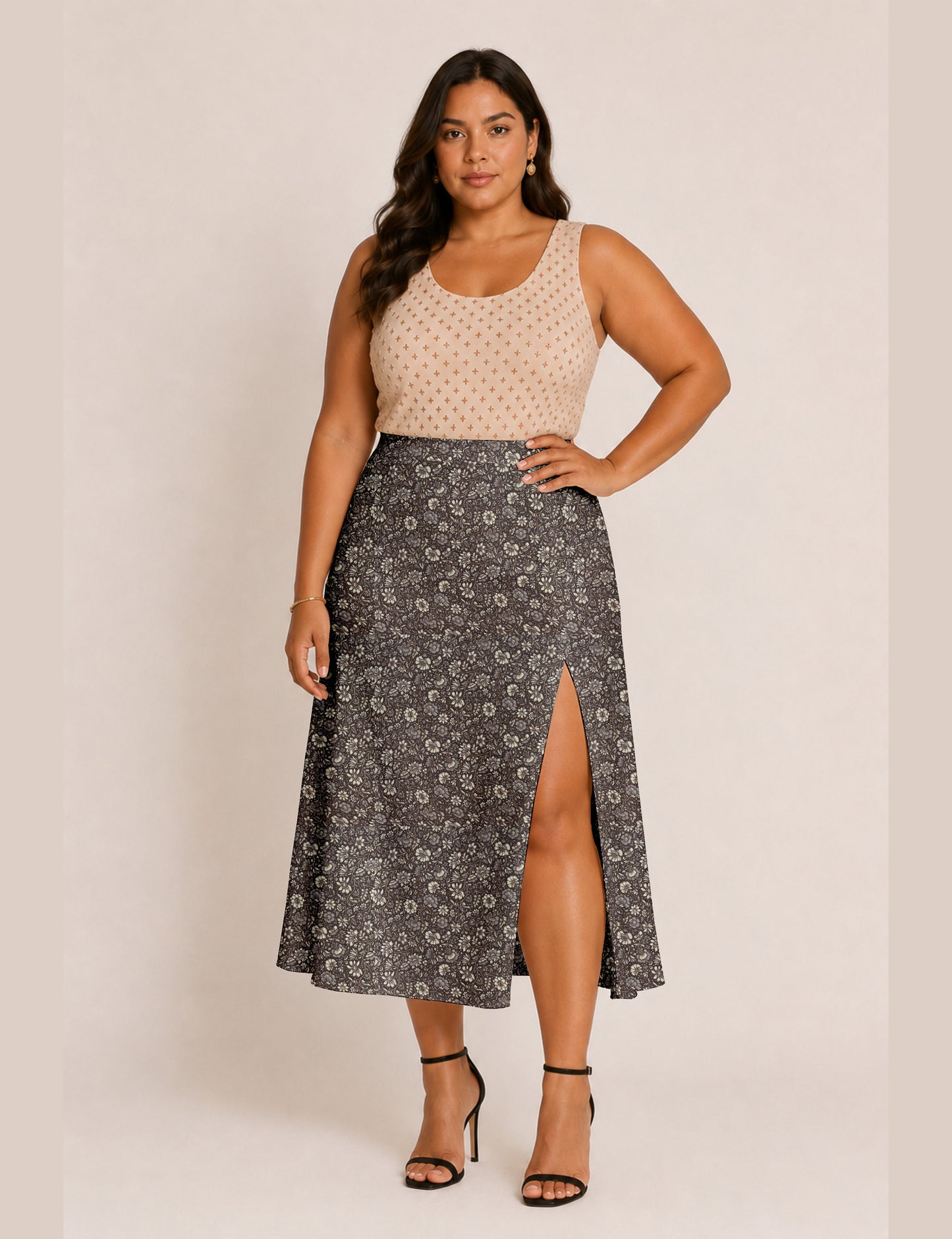 Woman wearing a yellow and black micro patterned A-line skirt with front slit, paired with beige sleeveless top and black