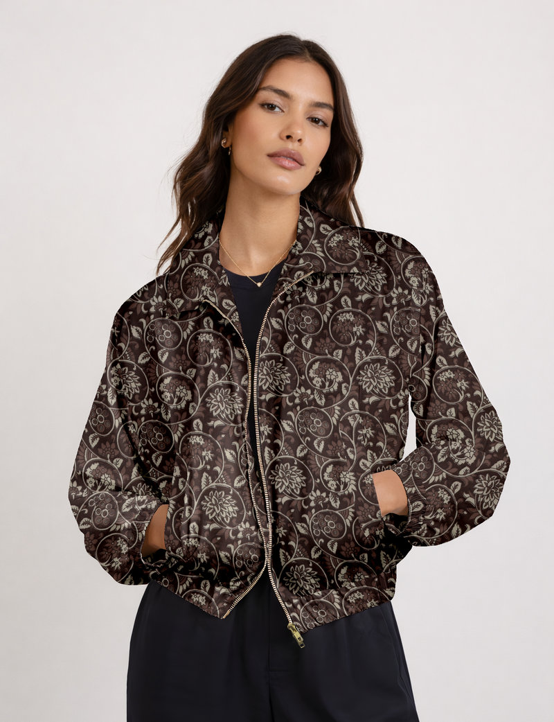 Woman wearing a brown floral bomber jacket with a front zipper, elastic cuffs, and side pockets, shown from the front