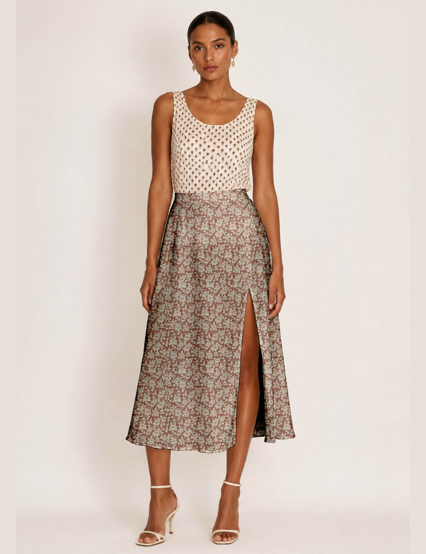 Woman wearing a yellow and black micro patterned A-line skirt with front slit, paired with beige sleeveless top and black