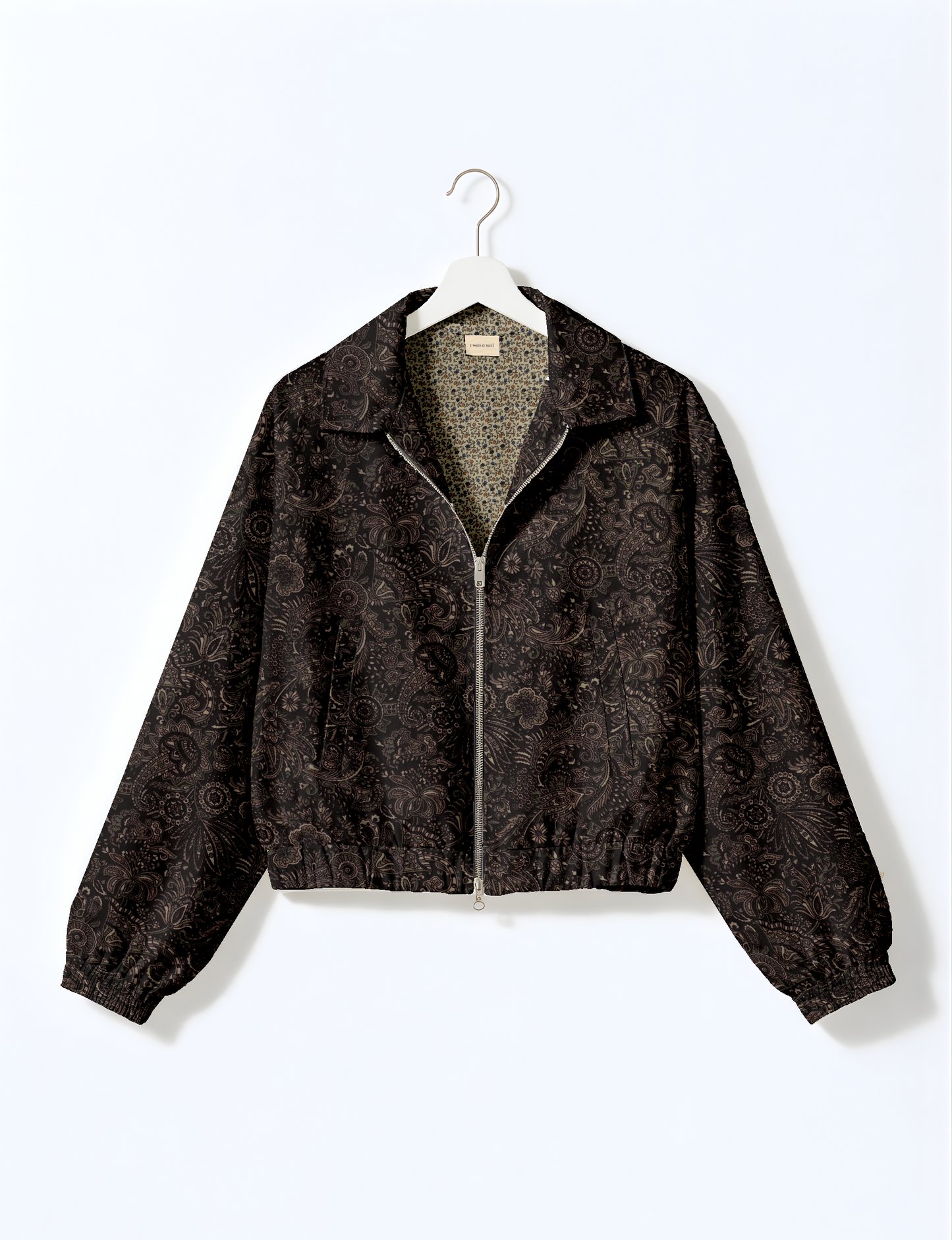 Women's cropped bomber jacket with twin metallic front zippers, welt pockets, elasticated hem and cuffs, and contrast sari print lining.
