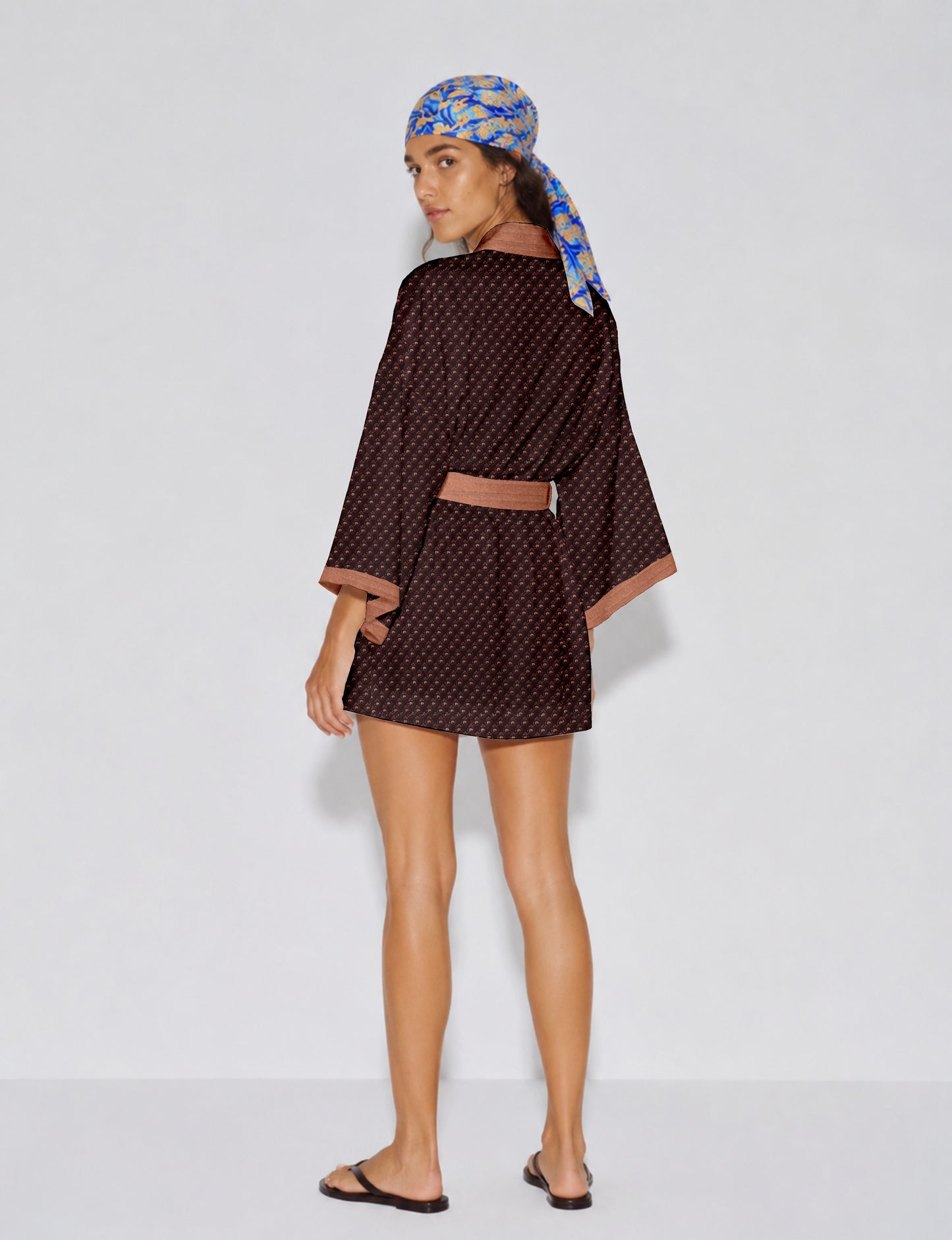Short kimono robe with wrap front, V-neckline, wide sleeves, waist tie, and concealed skort detail.