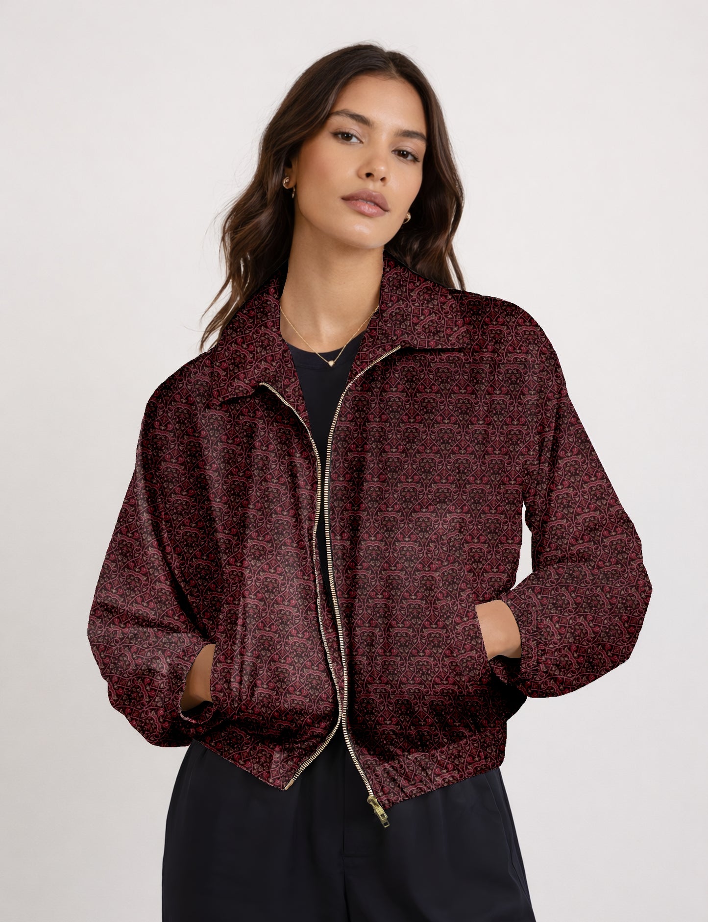 Woman wearing a yellow bomber jacket with a micro geometric pattern, front zipper, and side pockets, paired with black pants