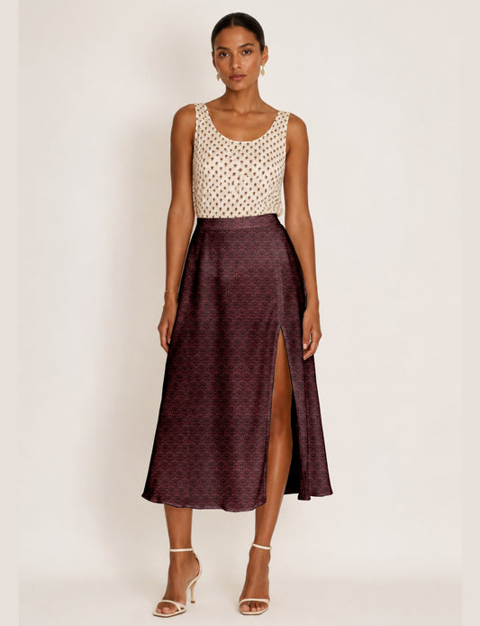 Woman wearing a yellow and black micro patterned A-line skirt with front slit, paired with beige sleeveless top and black