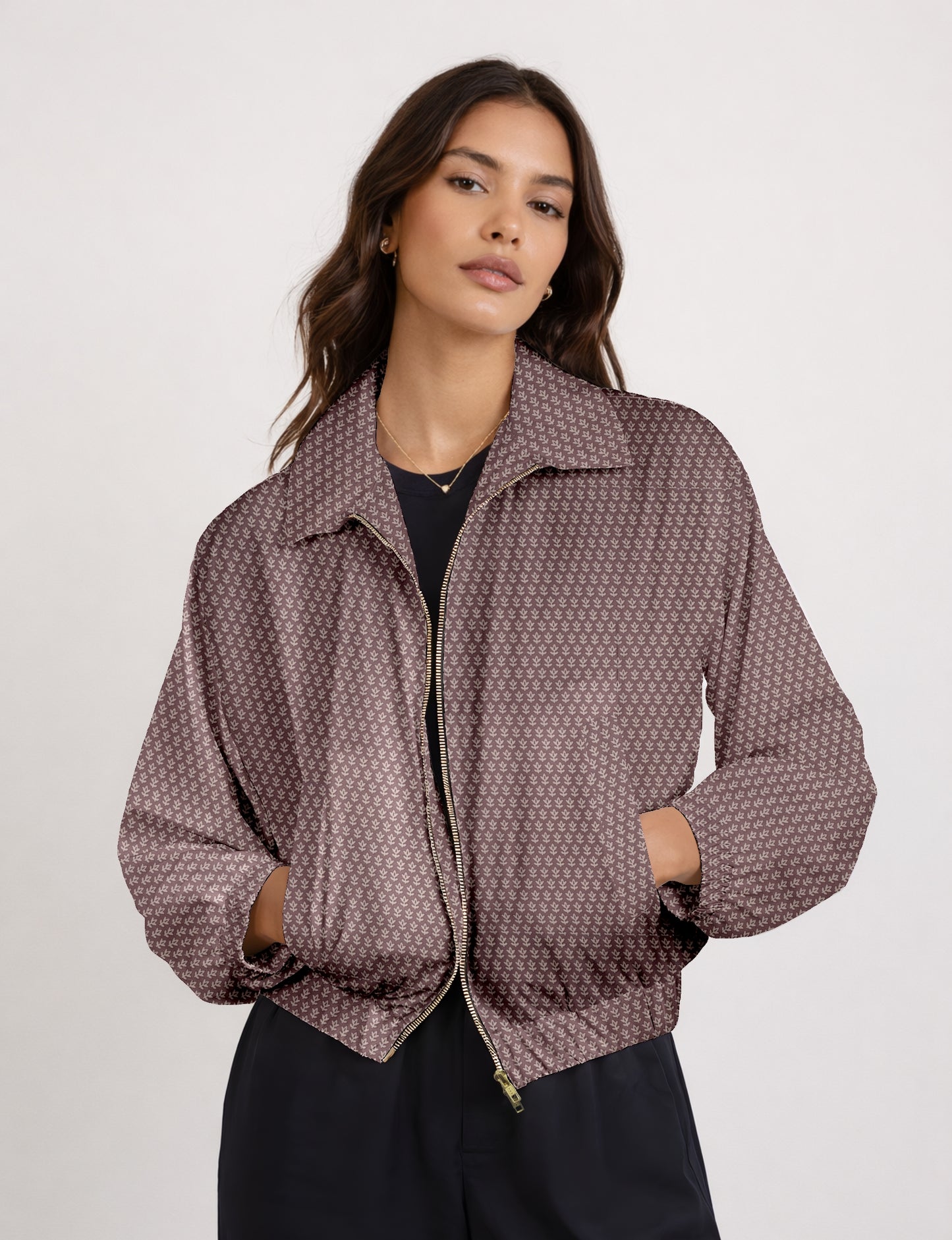 Woman wearing a yellow bomber jacket with a micro geometric pattern, front zipper, and side pockets, paired with black pants