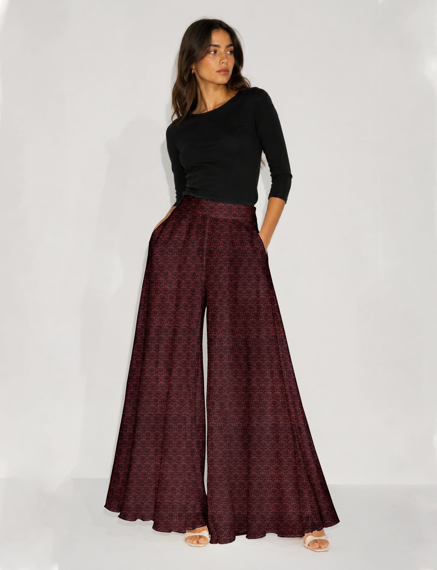 Woman wearing blue wide leg palazzo trousers with black and brown floral print, paired with brown sleeveless top and white