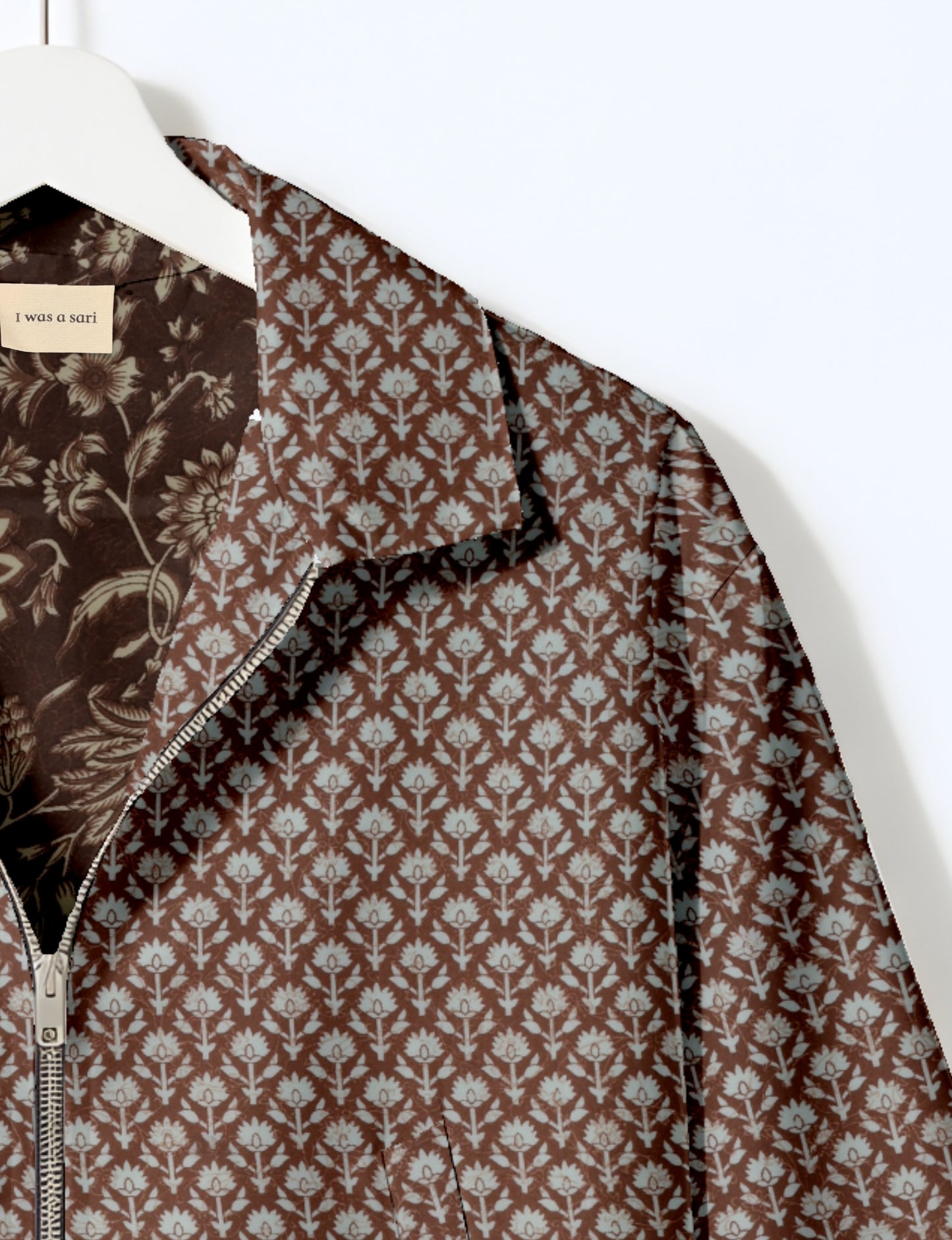 Women's cropped bomber jacket with twin metallic front zippers, welt pockets, elasticated hem and cuffs, and contrast sari print lining.