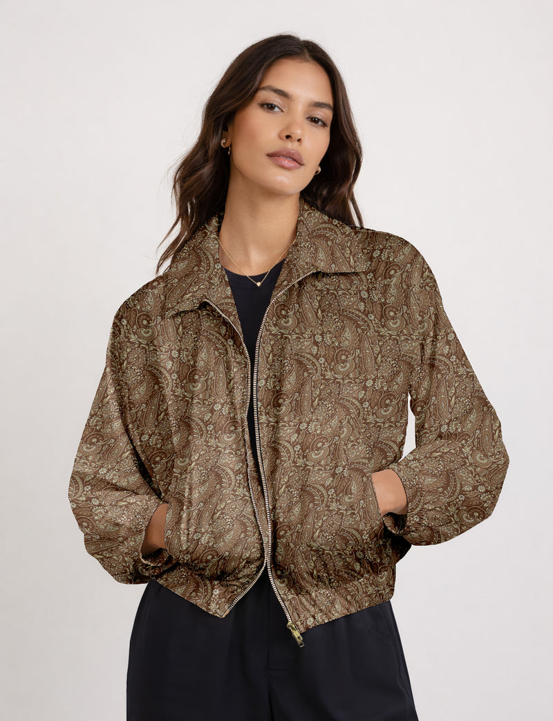 Woman wearing a yellow floral bomber jacket with front zipper, elastic cuffs, and side pockets, shown from front view