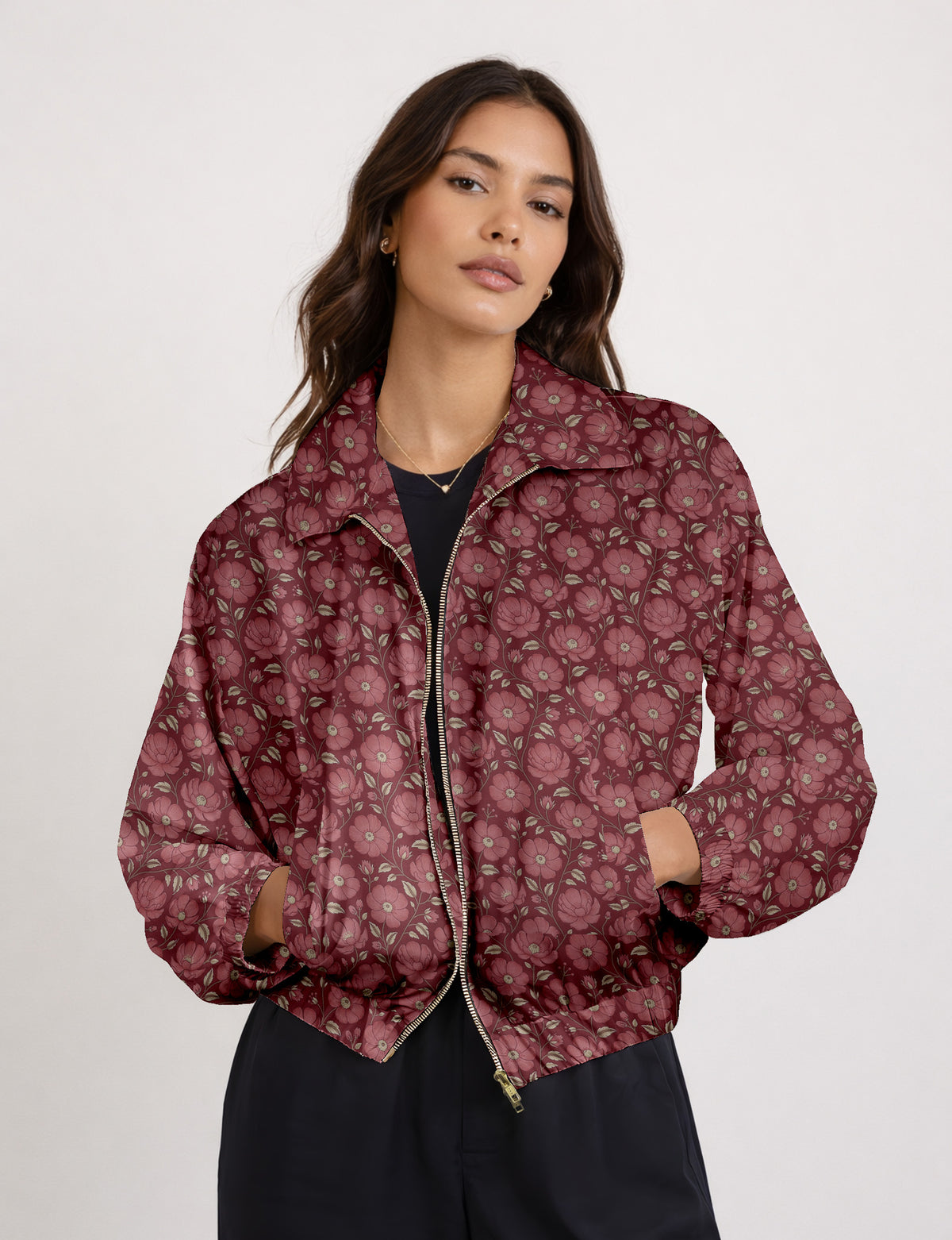 Woman wearing a yellow floral bomber jacket with front zipper, elastic cuffs, and side pockets, shown from front view