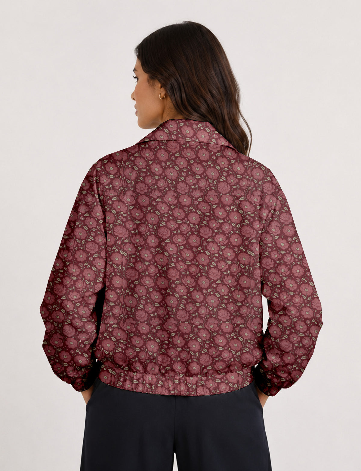 Woman wearing a yellow floral bomber jacket with front zipper, elastic cuffs, and side pockets, shown from front view