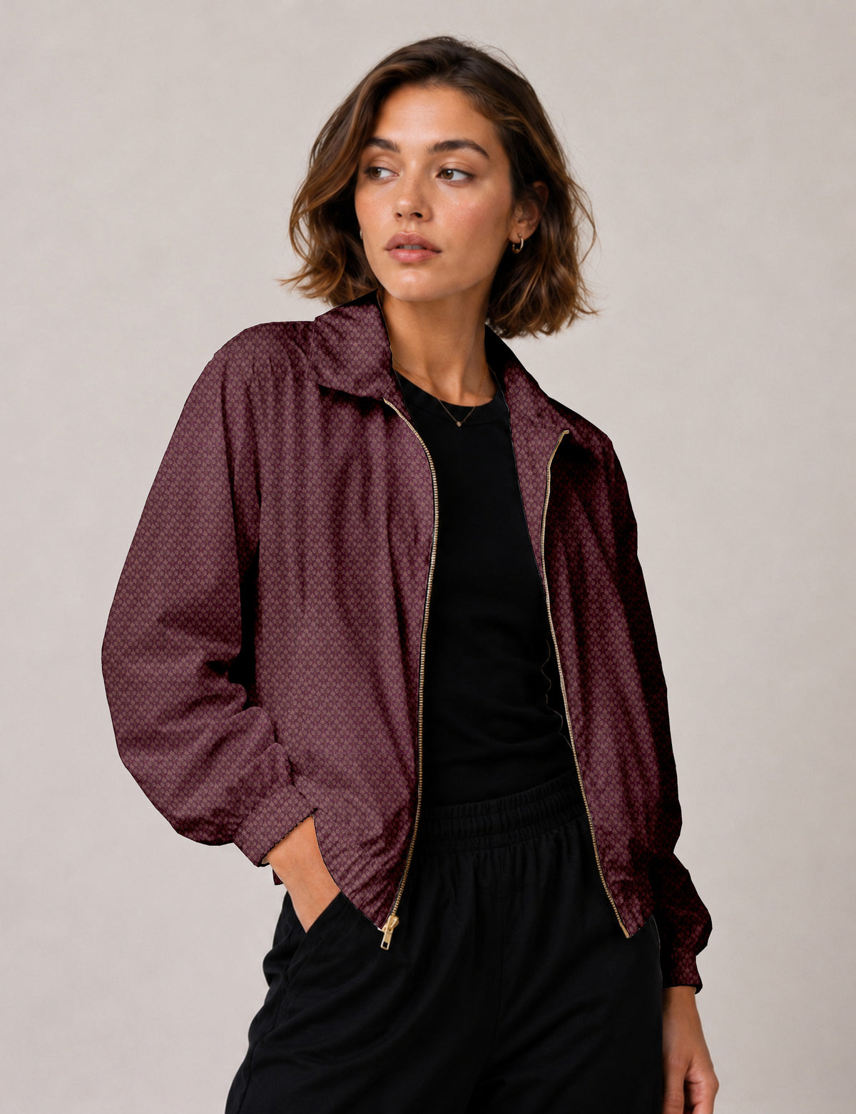 Woman wearing a yellow floral bomber jacket with front zipper, elastic cuffs, and side pockets, shown from front view