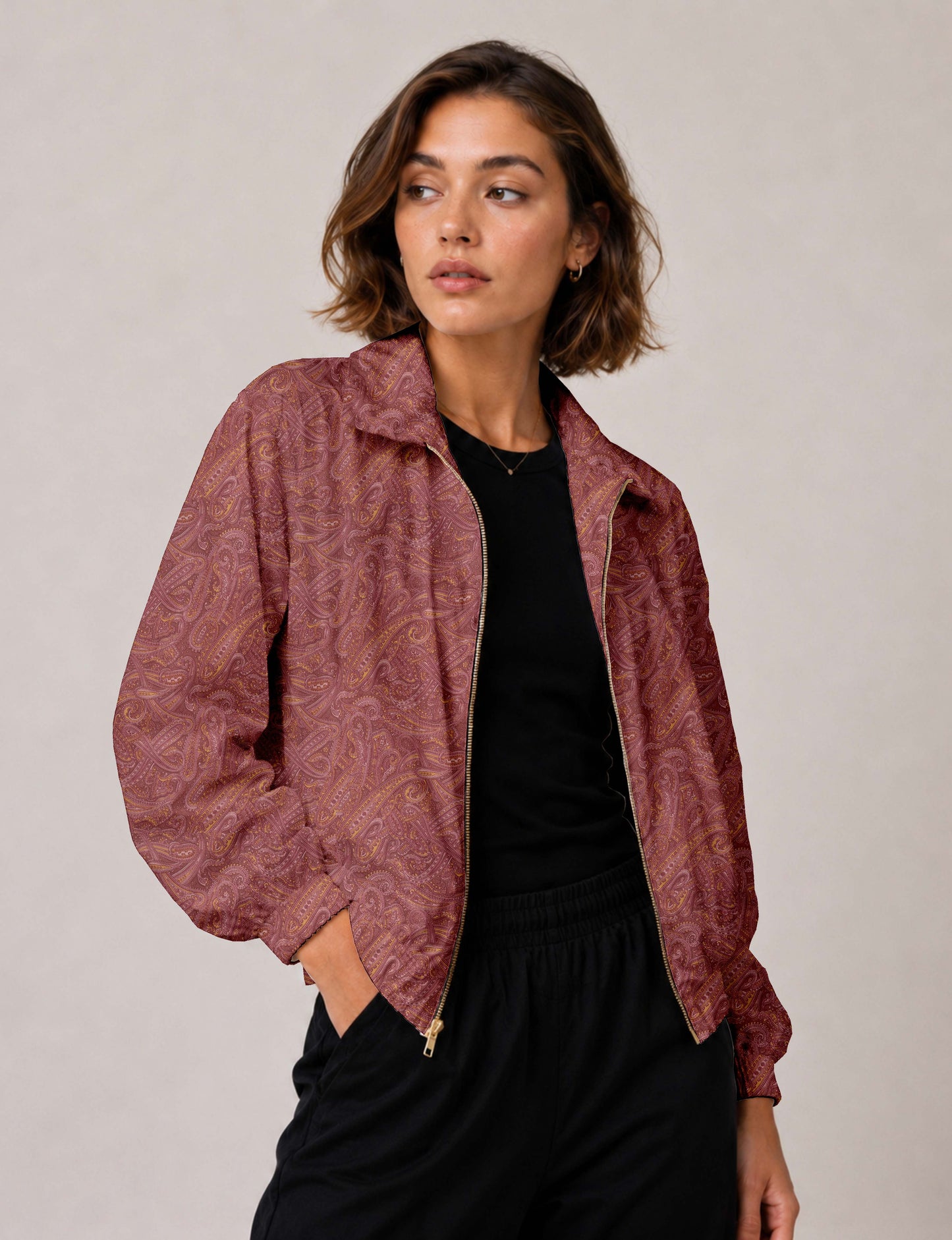 Brown floral bomber jacket with front zipper, elastic cuffs and hem, hanging on white hanger, red floral inner lining visible