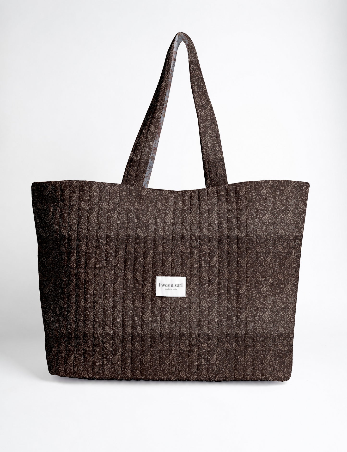 Large quilted beach bag with spacious rectangular design, reinforced shoulder straps, and open-top construction for everyday use and travel.