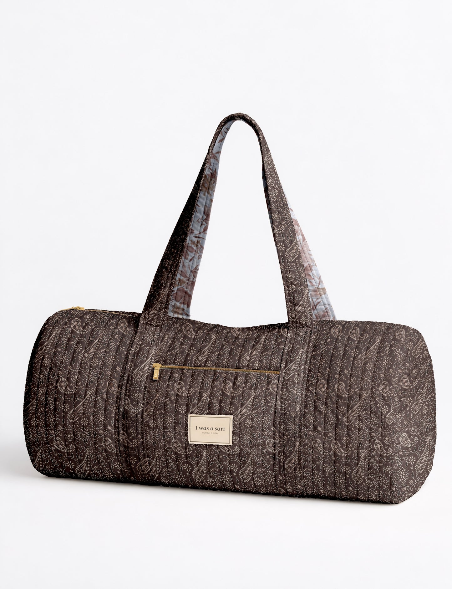 Beige quilted bowling bag with micro floral pattern, front zipper pocket, and dual handles with striped inner lining