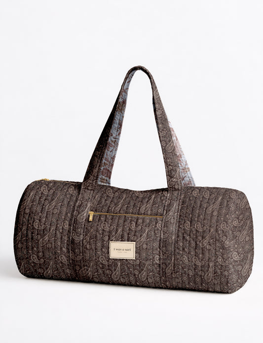 Beige quilted bowling bag with micro floral pattern, front zipper pocket, and dual handles with striped inner lining