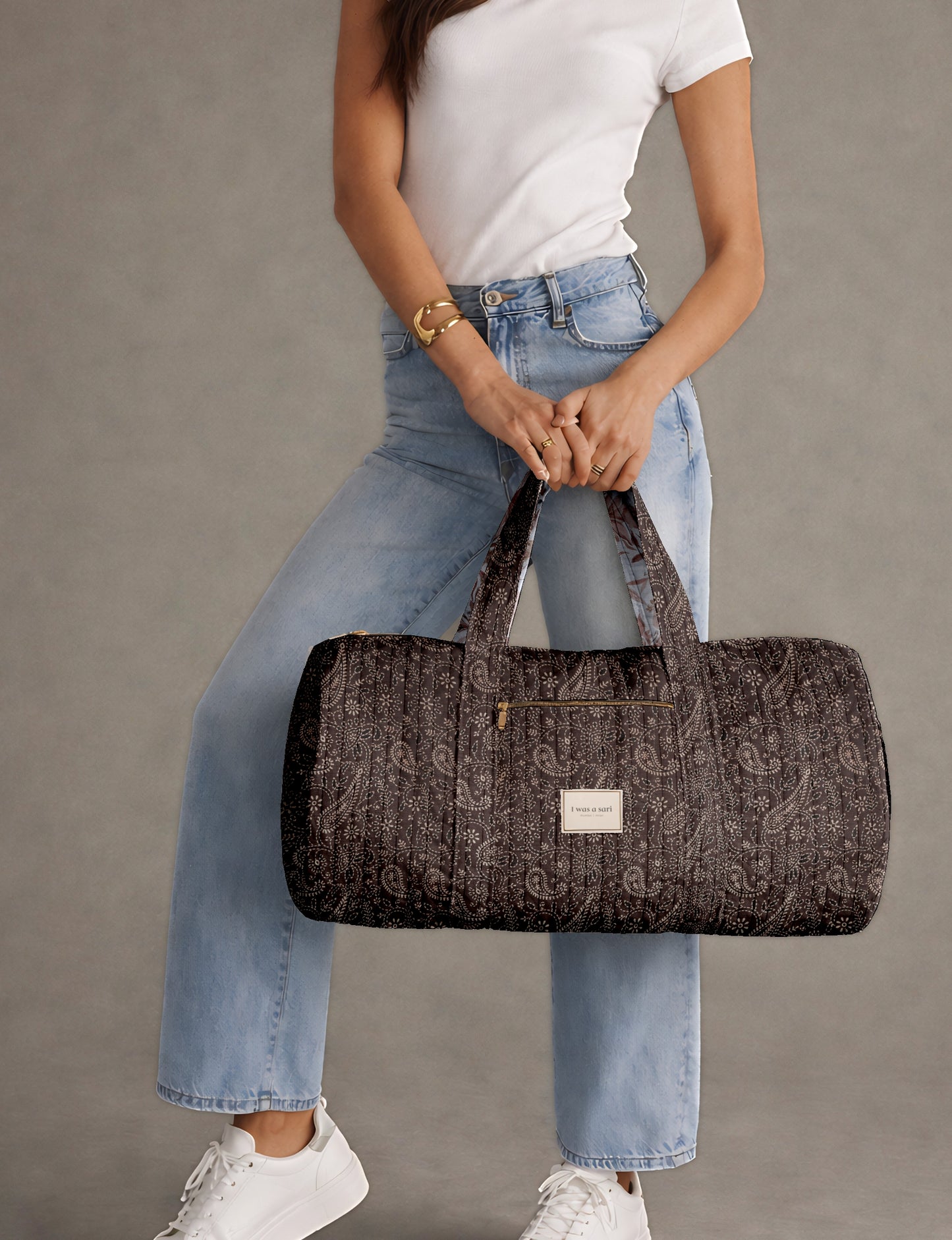Beige quilted bowling bag with micro floral print exterior and blue geometric patterned interior, open zipper view