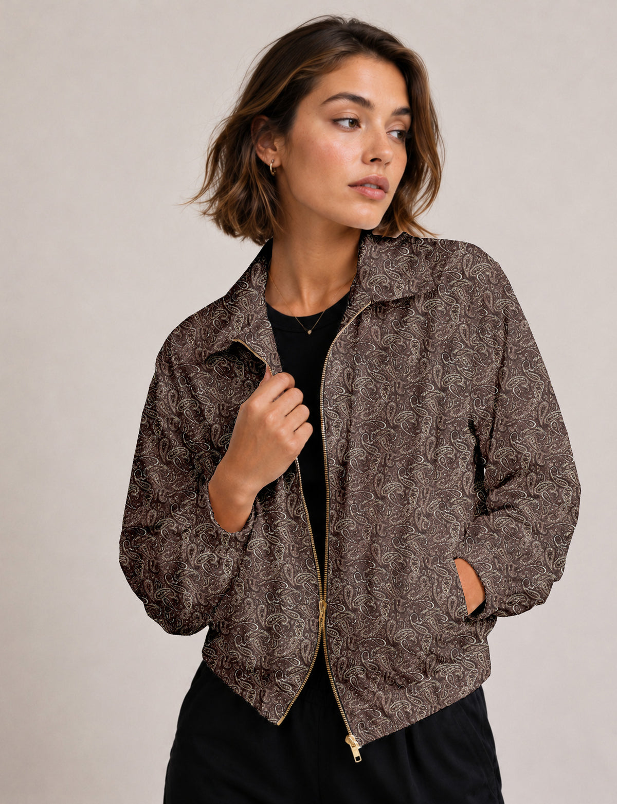 Brown floral bomber jacket with front zipper, elastic cuffs and hem, hanging on white hanger, red floral inner lining visible