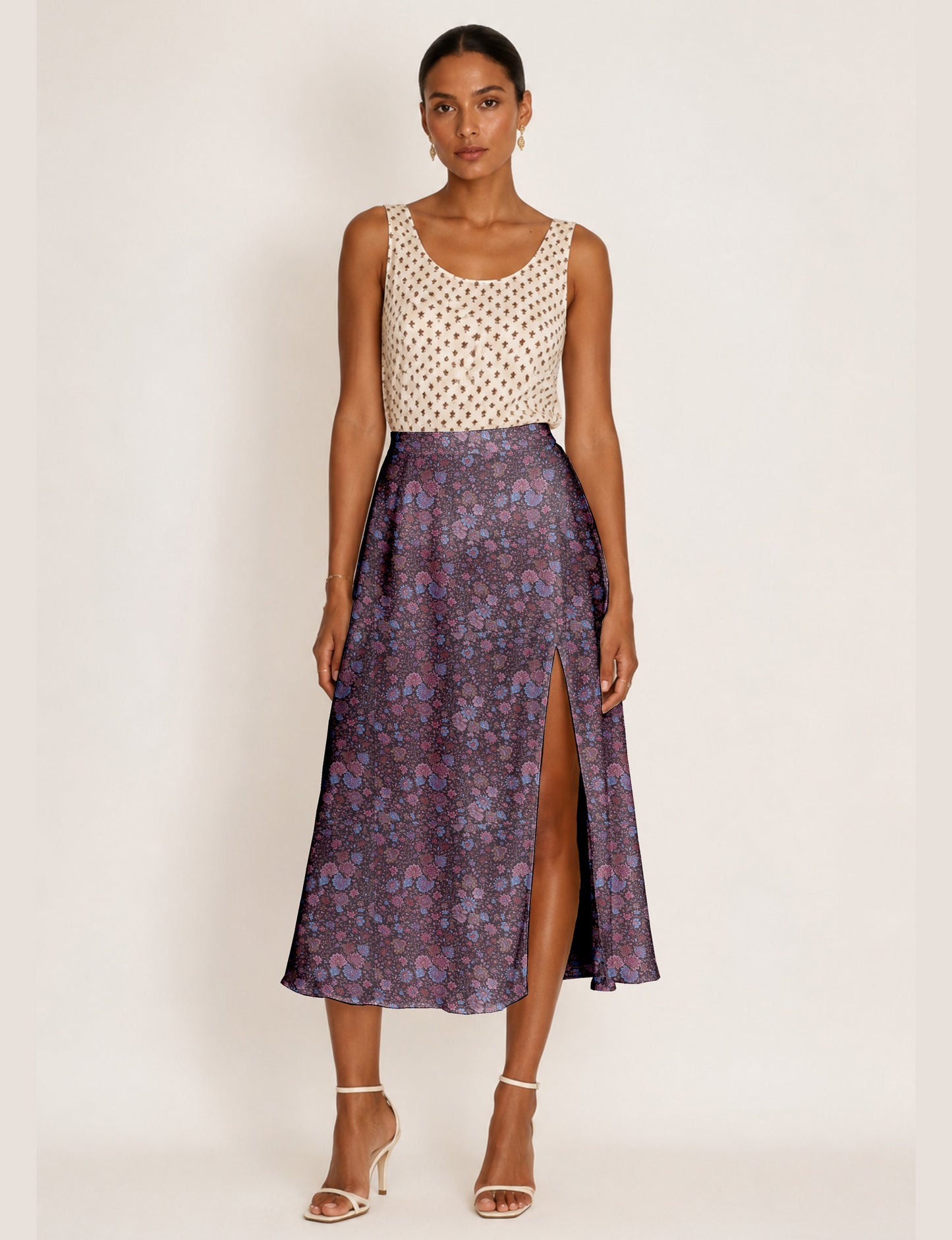 Woman wearing a yellow and black micro patterned A-line skirt with front slit, paired with beige sleeveless top and black